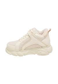 Beige Sneaker mit einem weichen Innenfutter, strukturierten Stoffpaneelen und einer dicken Gummisohle. Verfügt über eine Schnürung und eine Schlaufe an der Rückseite.