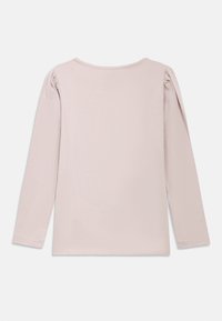 Bluzka z długim rękawem w jasnoróżowej bawełnie, z okrągłym dekoltem i marszczeniem na szwach barkowych. Gładka faktura o prostym kroju.