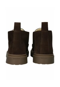 Hnědé semišové kotníkové boty s hladkým povrchem a zaoblenou špičkou. Gumová podrážka má mírný podpatek a vzadu se nachází poutko pro snadné obouvání.