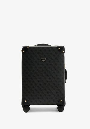 Valise rigide noire avec logo à motif subtil, coins dorés, quatre roues et une poignée supérieure.