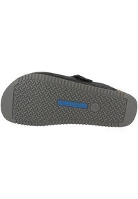 Black sandal with a textured grey outsole. Features include a rubber sole with a patterned tread and a blue logo detail. Adjustable strap.