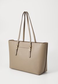 Beige leren totebag met een gestructureerd oppervlak, voorzien van twee lange handvatten en gouden hardware accenten. Eenvoudig en gestructureerd ontwerp.