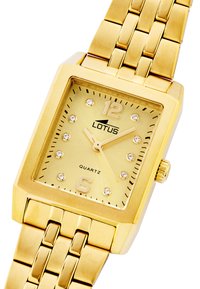 Reloj cuadrado de cuarzo en tono dorado con un dial texturizado, marcadores de cristal transparente y una pulsera metálica de eslabones. Marca: Lotus.