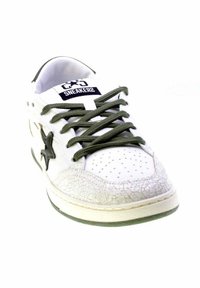 Sneaker bianca con lacci verdi e dettaglio a stella, punta perforata, copertura della punta testurizzata e etichetta "SNEAKERS" sulla linguetta.