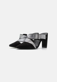 Mustad suede kõrgete kontsadega jalanõud terava ninaga, millel on ees ristikujuline rhinestone-kattes rihm ja avatud tagaosa.