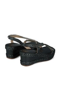 Sandali wedge neri con suola in juta intrecciata, cinturini decorati con piccoli dettagli metallici e design slingback.