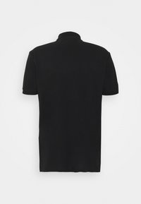 Polo noir à manches courtes en coton, doté d'un col classique et d'un ourlet droit. Texture lisse sans motifs apparents.