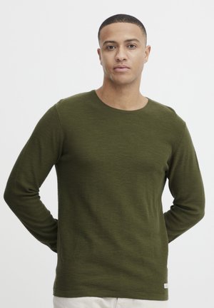 Olijfgroen longsleeve crewneck shirt met een gladde textuur, een aansluitende pasvorm en een labelaccent aan de zoom. Geen zichtbare patronen.