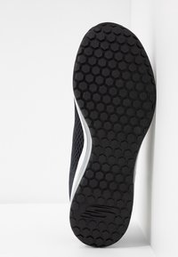 Svart sneaker-sula med ett texturerat bikake-mönster och böjda vita sidodetaljer. Har en ovandel i mesh för god andningsförmåga.