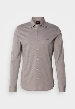 Chemise à manches longues gris clair avec un col boutonné, petit logo sur la poitrine gauche et boutons blancs. Fabriquée en tissu lisse avec une texture subtile.