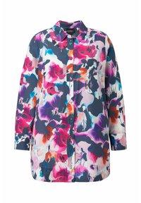 Chemise à manches longues avec col et boutons, présentant un imprimé floral abstrait en rose, violet, bleu, orange et noir sur fond blanc.