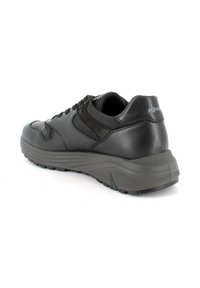 Sneaker in pelle nera con finitura testurizzata, dotata di una suola imbottita, punta tonda e sistema di allacciatura. Gli accessori includono un pannello laterale liscio.