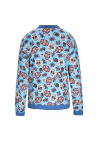 Pulover albastru cu maneci lungi, având un model vibrant cu skull-uri și flori, cu mansete și guler ondulat albastre. Textură moale a materialului.