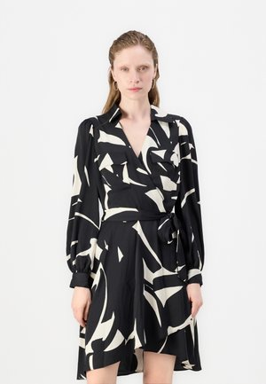 Black and cream wrap dress with long sleeves, featuring two front pockets, abstract pattern, and a tied waist for adjustment and fit.