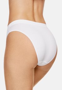 Białe bawełniane figi o gładkiej fakturze i bezszwowym designie, z miękkim elastycznym pasem i wysokim krojem nóg.