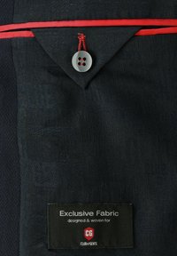 Dark navy fabric displays a subtle pattern and texture. Features a red accent trim, a round button, and a label stating "Exclusive Fabric."