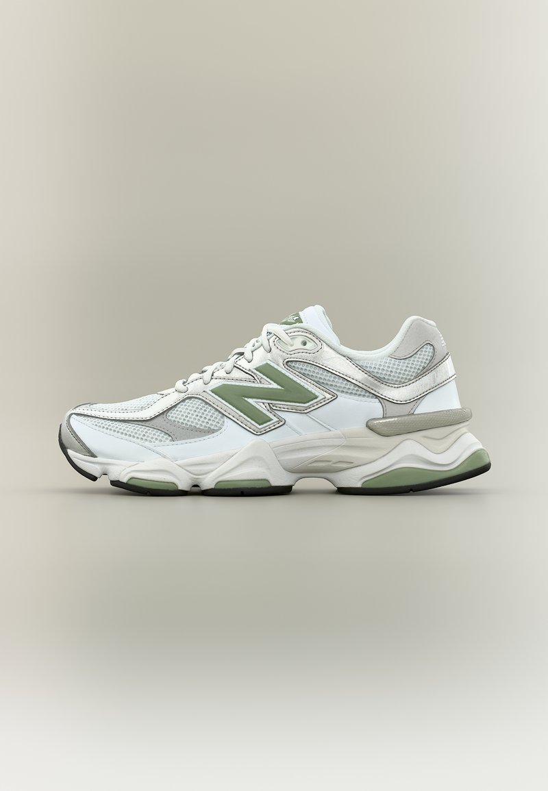 Λευκό και γκρι αθλητικό παπούτσι New Balance με πράσινες λεπτομέρειες, πάνελ από δίχτυ, κορδόνια και αναπαυτική σόλα, εμφανίζεται σε πλαϊνή όψη σε ουδέτερο φόντο.