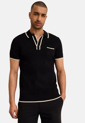 Polo shirt nero a coste con maniche corte, dettagli crema sul colletto e sulla tasca, dotato di una chiusura a tre bottoni e design aderente.