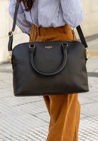 Black leather handbag with dual handles, detachable shoulder strap, gold-tone hardware, smooth texture, and zip closure.