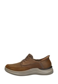 Zapatilla de cuero marrón con un perfil bajo, puntera redonda, cordones oscuros y acentos texturizados. Cuenta con una suela ligera y flexible y una superficie lisa.