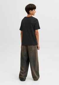 Zwart T-shirt met korte mouwen en een ronde hals, gecombineerd met loszittende, donkergrijze, gestructureerde wijde broekspijpen.