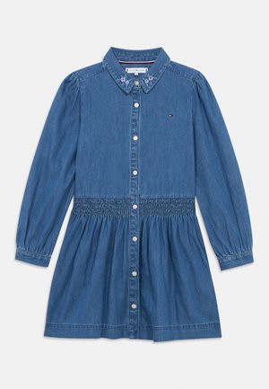 Τζιν φόρεμα με μακριά μανίκια, κουμπιά μπροστά, ελαστική μέση, κεντημένα λουλούδια στον γιακά και μικρό λογότυπο στην αριστερή πλευρά του στήθους.