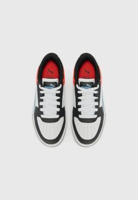 Zwart-witte sneakers met rode accenten, geperforeerde neus, witte veters, een gevoerde kraag en een blauw logo aan de zijkant.