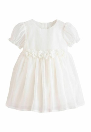 Hvid kjole med korte ærmer lavet af letvægtsstof, med en blomsterudsmykning ved taljen og en udstående nederdel med subtil tekstur.