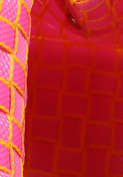 Cesto intrecciato in plastica con un corpo fucsia brillante e accenti gialli. Presenta una superficie texture e un motivo a griglia visibile.