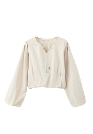 Blusa beige de manga larga con escote redondo y cordón, con mangas ligeramente abullonadas y un corte suelto.