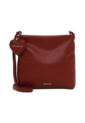 Sac bandoulière en cuir rouge avec une finition texturée, une sangle réglable et une étiquette en forme de cœur avec le nom de la marque embossé dessus.