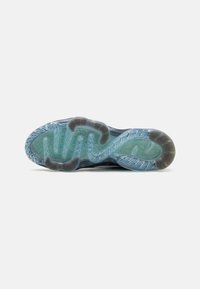 Sulan på skon har en vågig design; genomskinlig blå gummi med texturerad yta och mörkgrå detaljer; räfflade mönster förbättrar greppet.