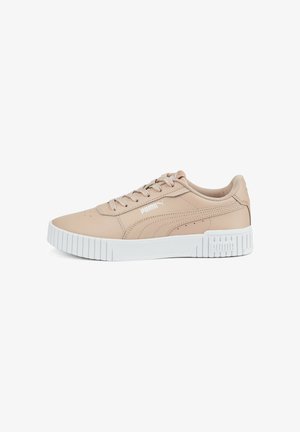 Baskets basses Puma beige avec semelle blanche épaisse, coutures apparentes, fermeture à lacets, et logo Puma sur le côté et le talon.