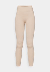 Leggings acanalados en un tono beige claro. Presenta una cintura alta y una forma de pierna ajustada, confeccionados con un material suave y elástico.