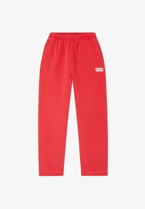 Červené tepláky vyrobené z mäkkej látky, s elastickým pásom a s textom "AMERICAN VINTAGE" vytlačeným bielou farbou na ľavom stehne.