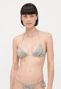 Gray bikini set featuring a triangle top with silver and gold studs, thin ties, and a side-tie bottom, showcasing a smooth texture.