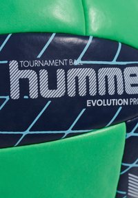 Grön och marinblå fotboll med texturerade paneler, utrustad med tryckt logotyp och vita diagonala linjer, designad för turneringsanvändning.