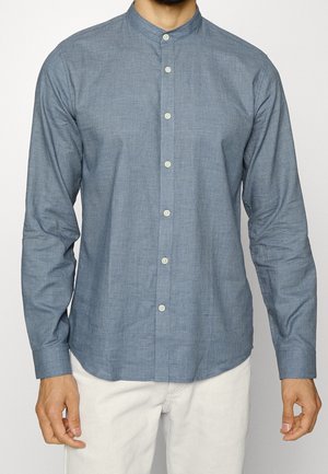 Camicia a maniche lunghe con bottoni in tessuto blu chiaro con una trama texture, dotata di colletto alla mandarina e bottoni bianchi.