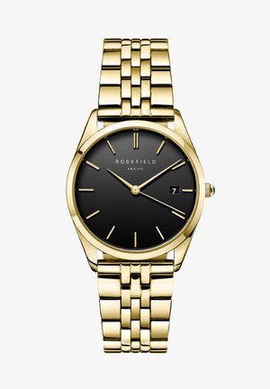 Montre en métal doré avec un cadran noir, des index fins et une fonction date. Le bracelet a un design à maillons, et le boîtier est rond avec une finition lisse.