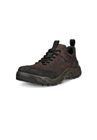 Zapatillas de deporte de cuero marrón y tela con suela de goma negra, que presentan acentos perforados y una pestaña en el talón para facilitar su puesta.