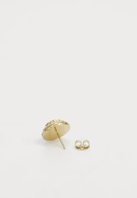 Boucle d'oreille circulaire en or avec surface texturée et petits embellissements, présentée avec un fermoir en métal séparé.