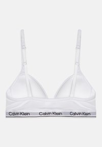 Bralette bianco con spalline regolabili, tessuto morbido e coppa a forma triangolare. Presenta una fascia con logo nera e grigia nella parte inferiore.