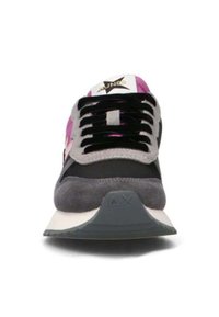 Vista frontale di una sneaker con lacci neri, camoscio grigio, tessuto nero e rosa, e suola bianca con punta grigia contrassegnata con "ΔX".