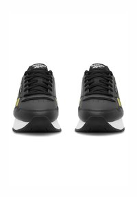 Čierne športové topánky s bielou podrážkou, so žltými akcentmi, okrúhlou špičkou a plochými šnúrkami. Hladký kožený zvršok s textúrovanými detailmi.