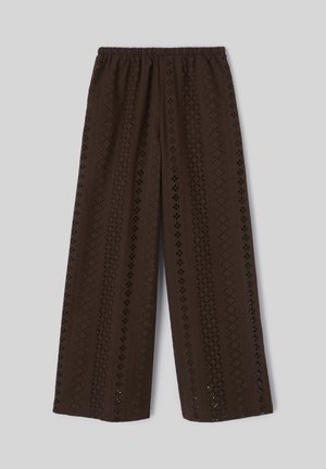 Pantalon marron à jambes larges avec des motifs verticaux en dentelle ajourée et une taille élastique, posé à plat sur un fond gris clair.