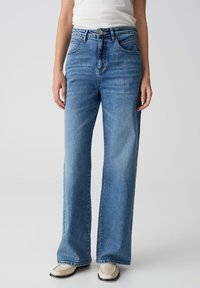 Lichtblauwe hoge taille jeans met brede pijpen, gemaakt van denim. Beschikt over een klassiek vijf-pocket ontwerp en een metalen knoopsluiting.