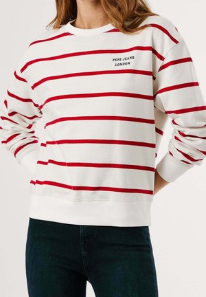 Biała koszula z długim rękawem z czerwonymi poziomymi paskami i napisem "PEPE JEANS LONDON", noszona z ciemnoniebieskimi dżinsami, model przycięty na ramionach.