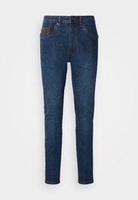 Donkerblauwe denim jeans met een recht model, vijf zakken, contrasterende stiksels en een knoopsluiting bij de taille.