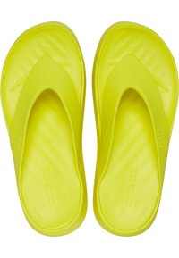 Des tongs jaunes vives en caoutchouc souple, présentant un design minimaliste avec une semelle moulée et une texture lisse.