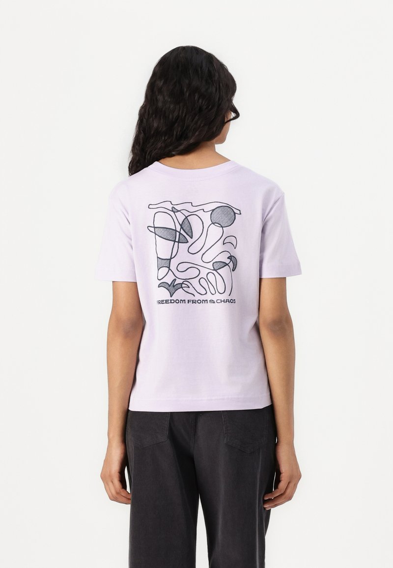 Lilac cotton t-shirt featuring a back abstract graphic in black lines with the text "FREEDOM FROM CHAOS" at the bottom. Short sleeves.